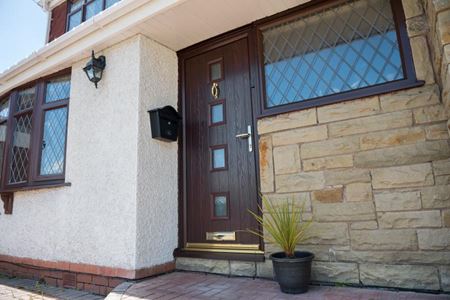 Contemporary composite front door finished in Dark Woodgrain from the Anglian composite doors range