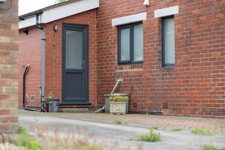 Half glazed UPVC back door finished in Anthracite Grey with matching grey windows from the Anglian UPVC range