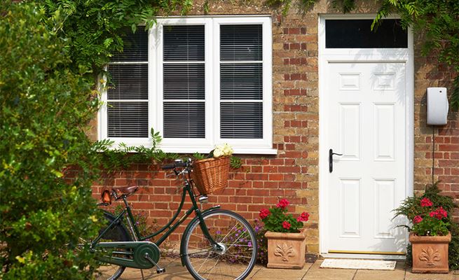 White UPVC double glazed casement window with cottage bars and composite back door from Anglian Home Improvements