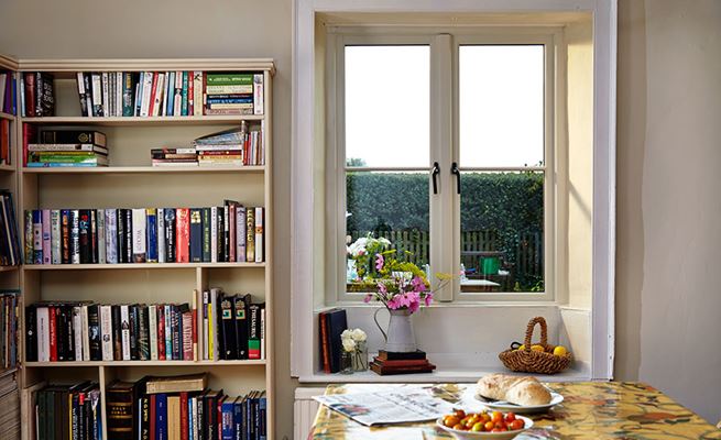 White wooden side hung casement windows with black window handles and central mullion from Anglian Home Improvements 