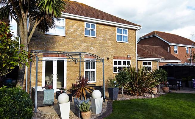 White UPVC casement windows with double glazing and French doors back of house view