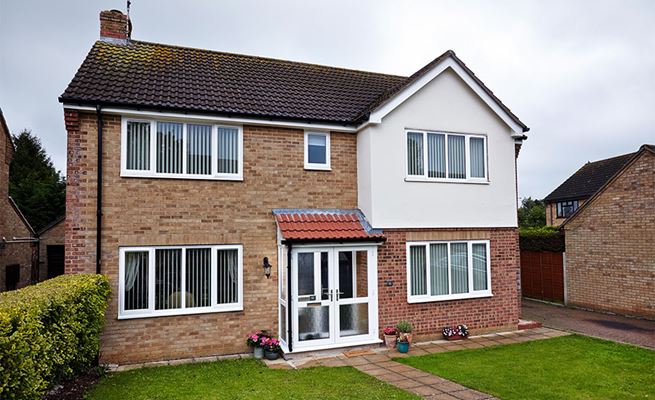 Full house renovation with White UPVC double glazed windows and front door porch and black guttering from Anglian Home Improvements