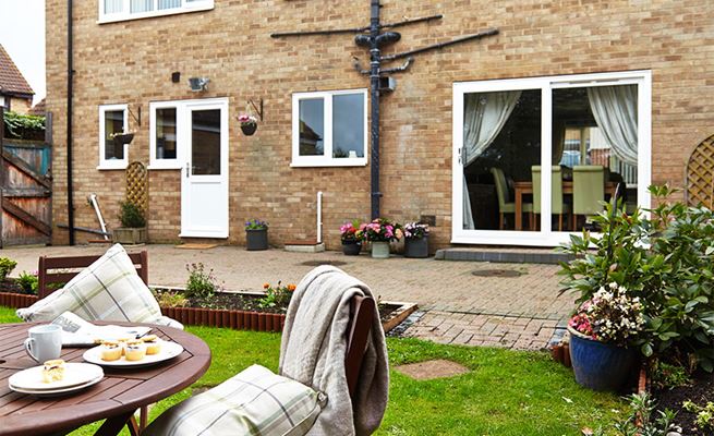 View from the garden of white uPVC sliding patio doors and half glazed uPVC back door from the Anglian doors range