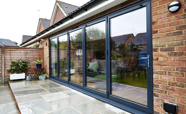 Anthracite Grey aluminium bi-fold doors made up of five panels on a modern extension from the Anglian bi-fold doors range