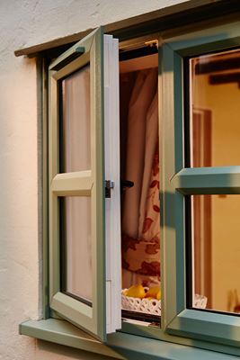 Open UPVC casement window showing dual colour Sage Green outside and White inside from Anglian Home Improvements