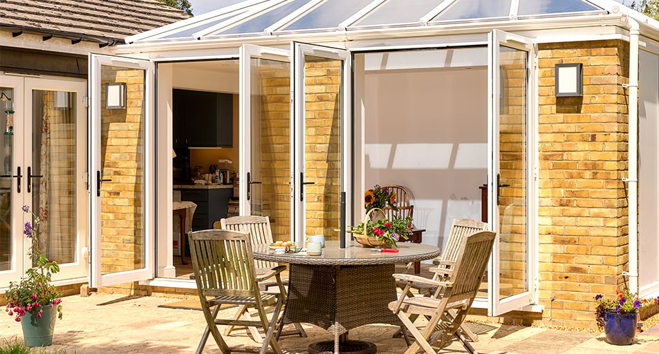 Two Open White uPVC French Doors with Black Handles on a Brick Pillar Orangery