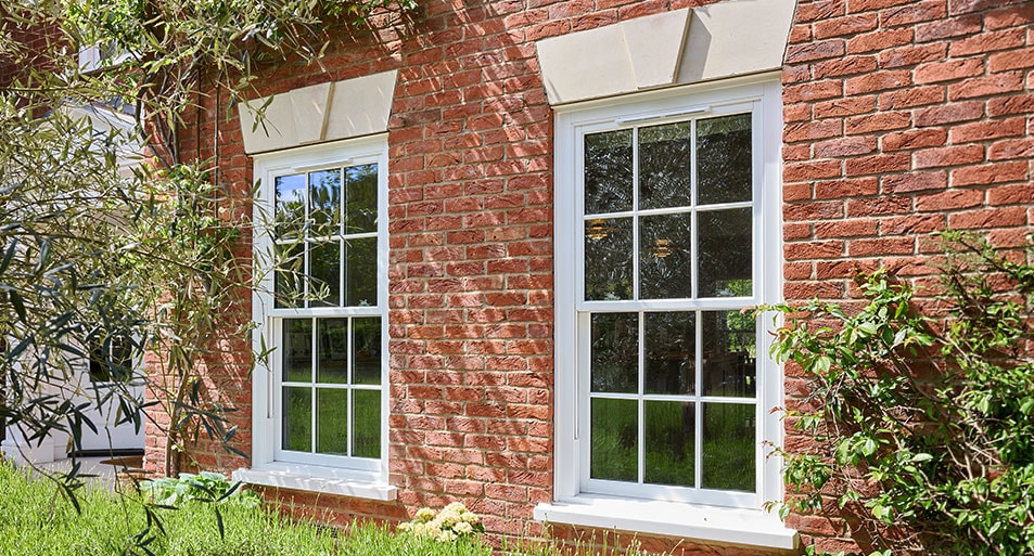 White uPVC Sliding Sash Windows in a Georgian Chequerboard Design on a Red Brick House