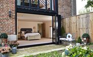 Jet Black aluminium bi-fold doors with five panels opening on a groundfloor bedroom barn conversion