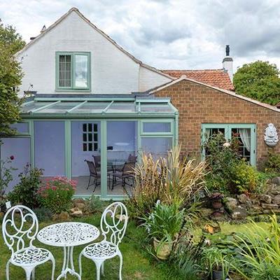 Dual Sage green uPVC lean to with French doors and casement windows
