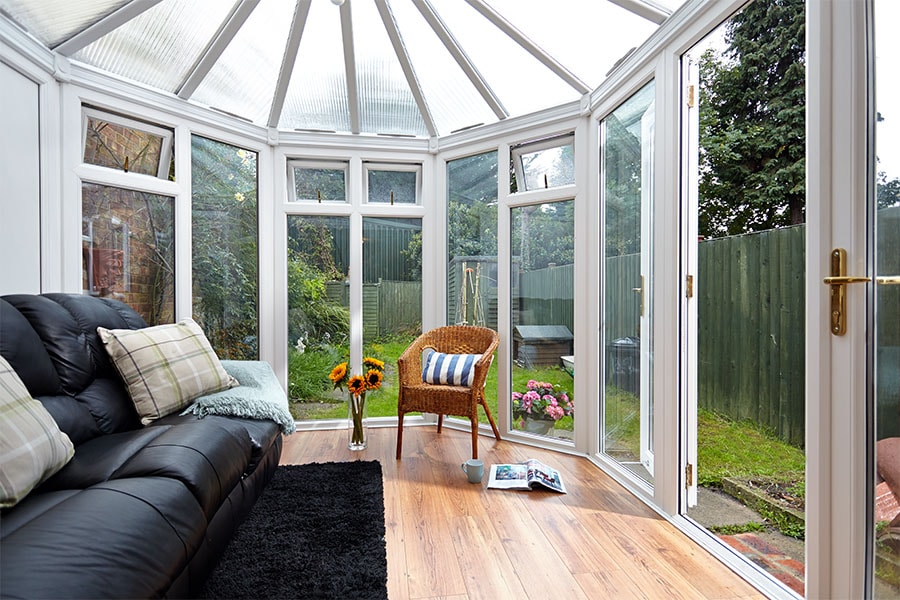 White uPVC Victorian conservatory with polycrbonate roof and French doors interior