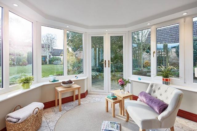Interior view of solid roof conservatory with White UPVC casement windows and French doors with gold handles from Anglian Home Improvements