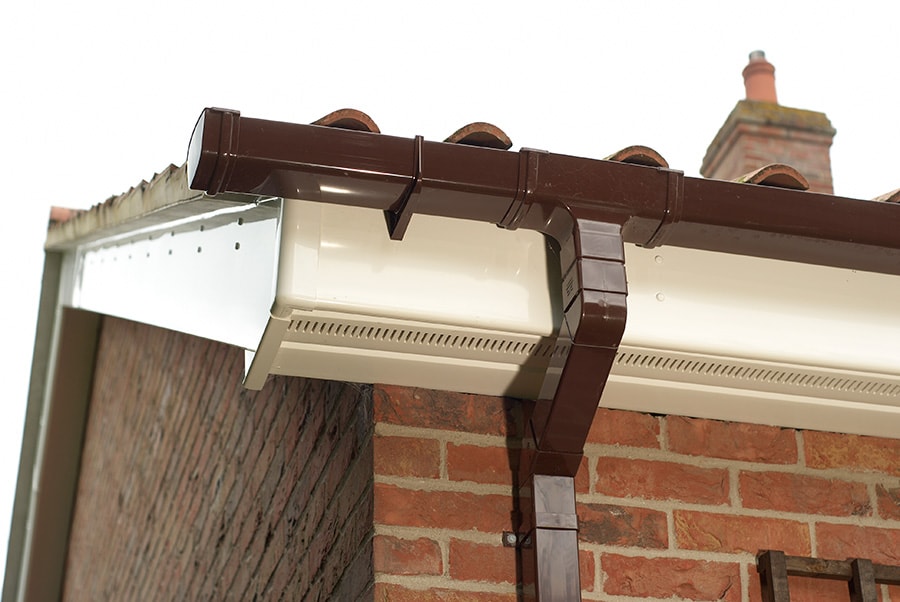 White uPVC bargeboard with brown guttering close up