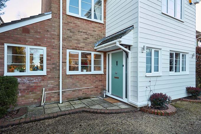 White uPVC cladding with sage green back door